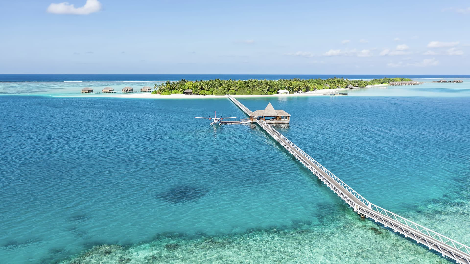 Luftaufnahme des Conrad Maldives Rangali Island mit den charakteristischen Wasserbungalows und türkisblauer Lagune