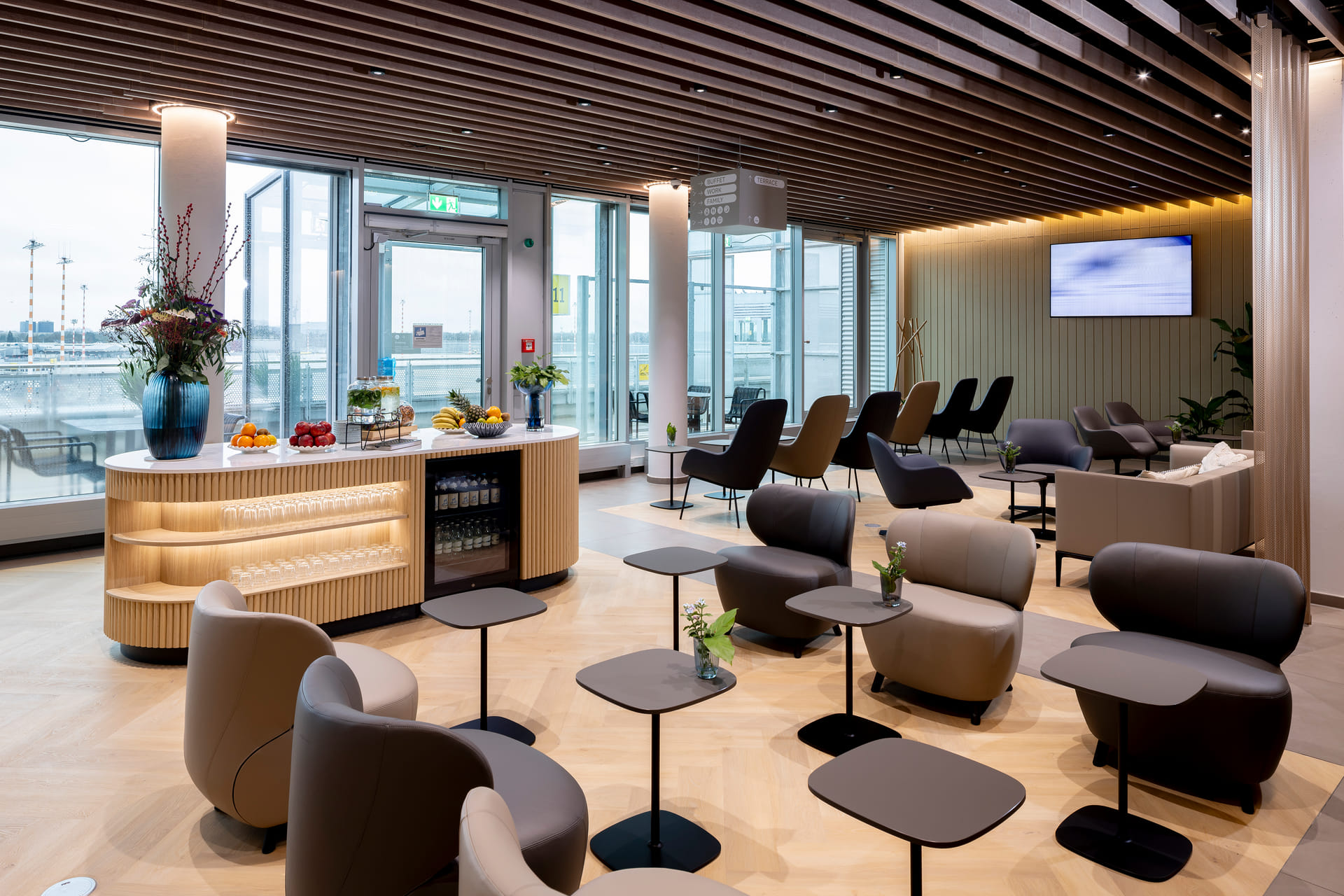 Moderne Inneneinrichtung der DUS Rhein Lounge am Flughafen Düsseldorf mit hochwertigen Designermöbeln von Walter Knoll und Blick auf das Vorfeld.