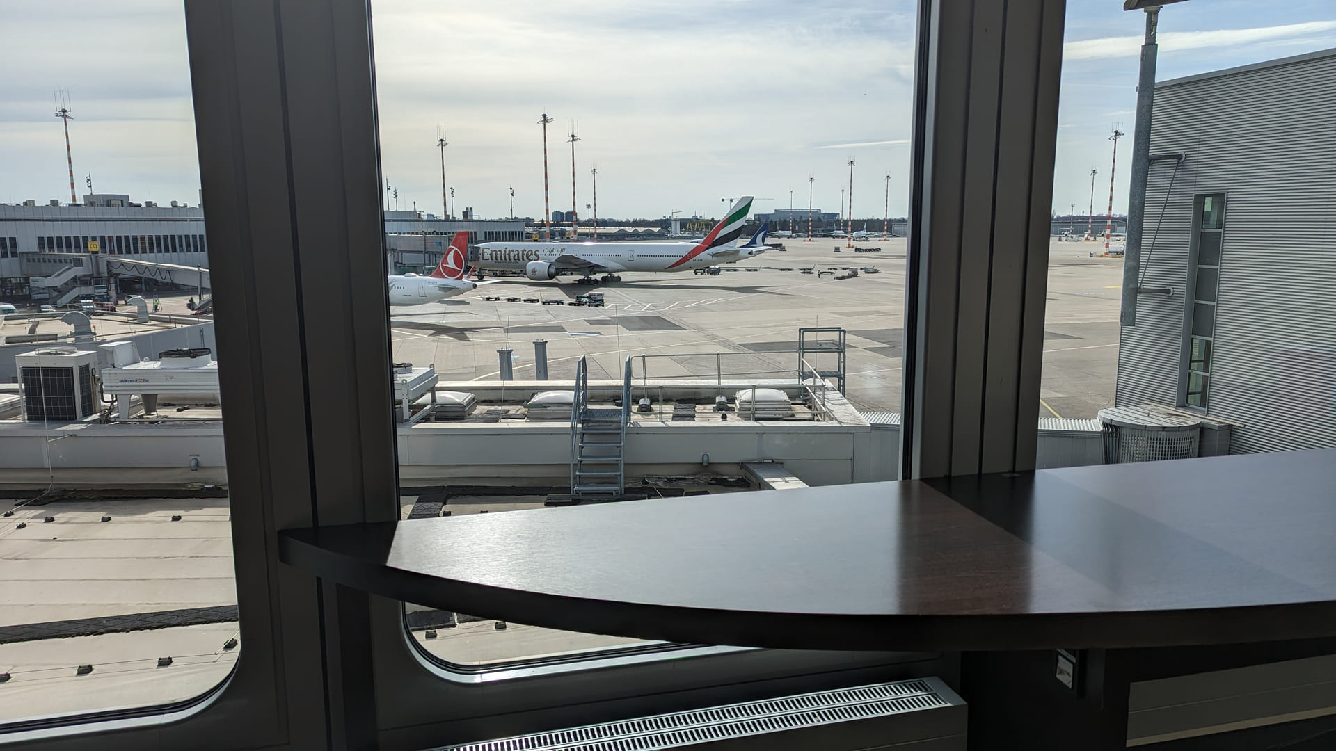 Panoramablick aus der Hugo Junkers Lounge Düsseldorf auf das Rollfeld und geparkte Flugzeuge.