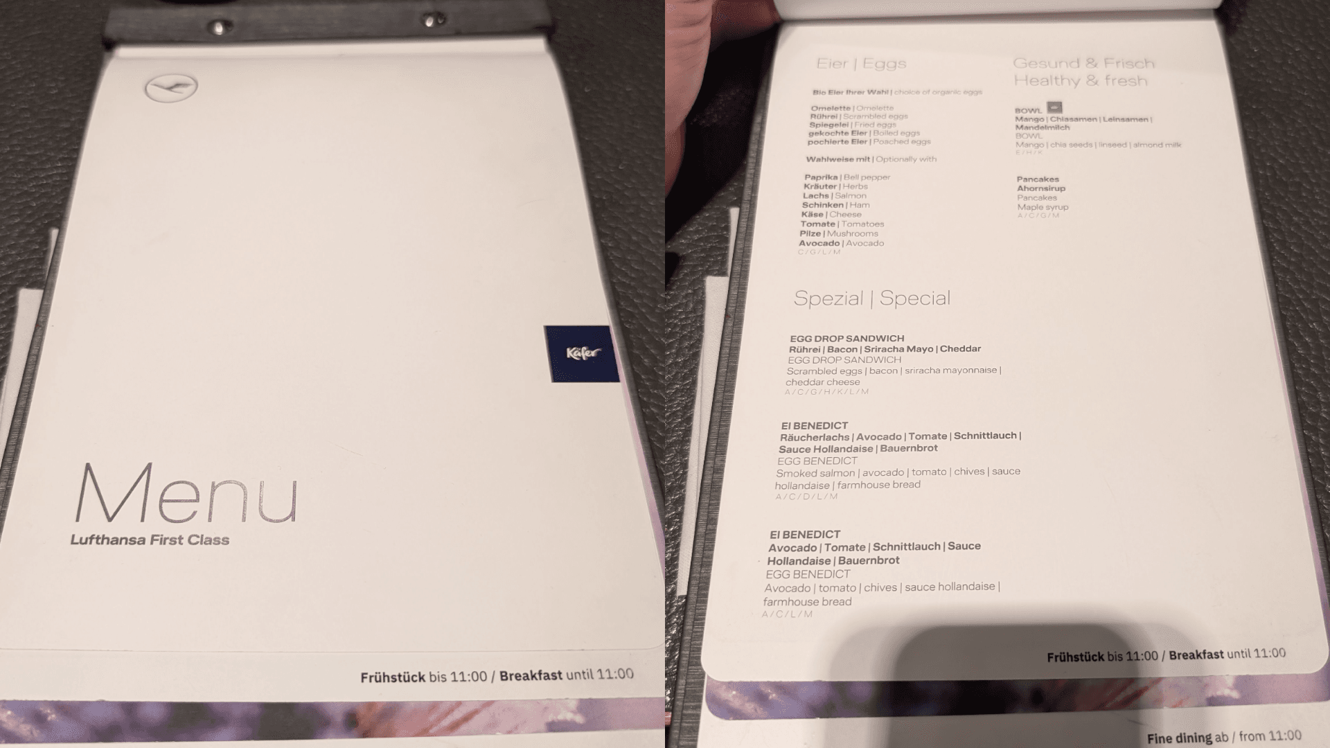 Collage aus zwei Bildern der Speisekarte. Links das schlichte weiße Cover mit dem silbernen Aufdruck „Menu Lufthansa First Class“. Rechts die Innenseite mit dem Frühstücksangebot bis 11:00 Uhr, das Eierspeisen, Bowls, Pancakes und Spezialitäten wie „Egg Drop Sandwich“ oder „Ei Benedict“ auflistet.